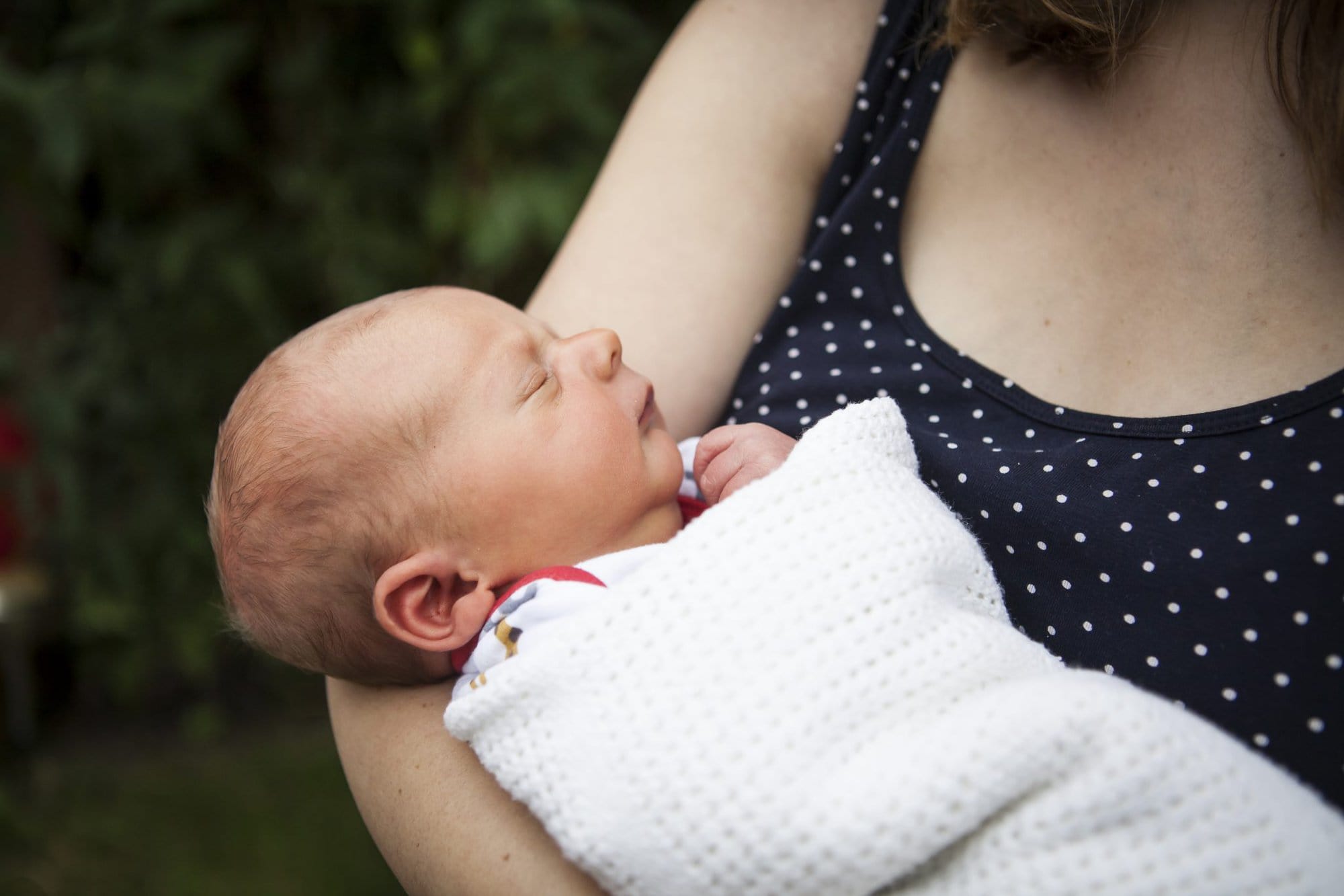 Baby cradled in mum's arms in newborn photoshoot in London