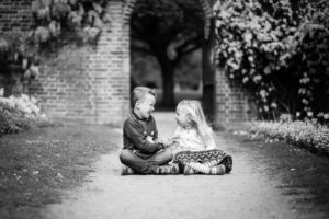 Brother and sister laughing in a park, South East London taken during family photoshoot