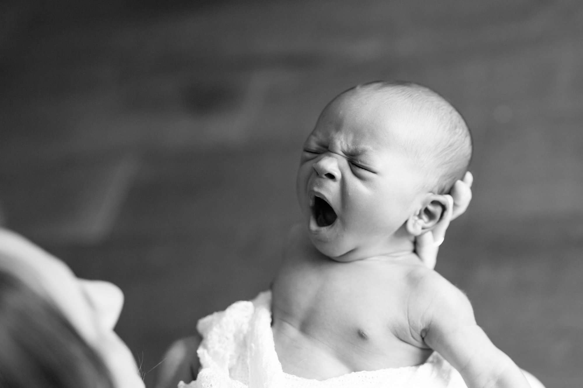 Baby yawning in newborn photoshoot in Bromley at parents home