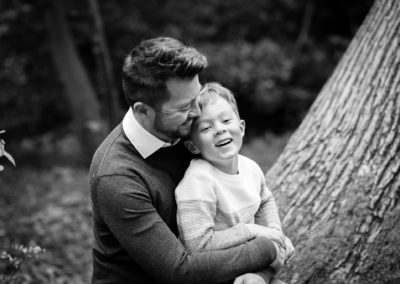 dad and son cuddling in black and white outdoor photo taken on Bromley photoshoot