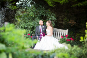 newly married couple sat on bench at Oaks Farm Weddings - taken by Tessa Clements Photography