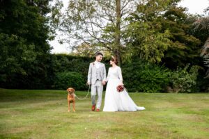 Couple with dog on wedding day at Oaks farm photographed by Bromley wedding photographer