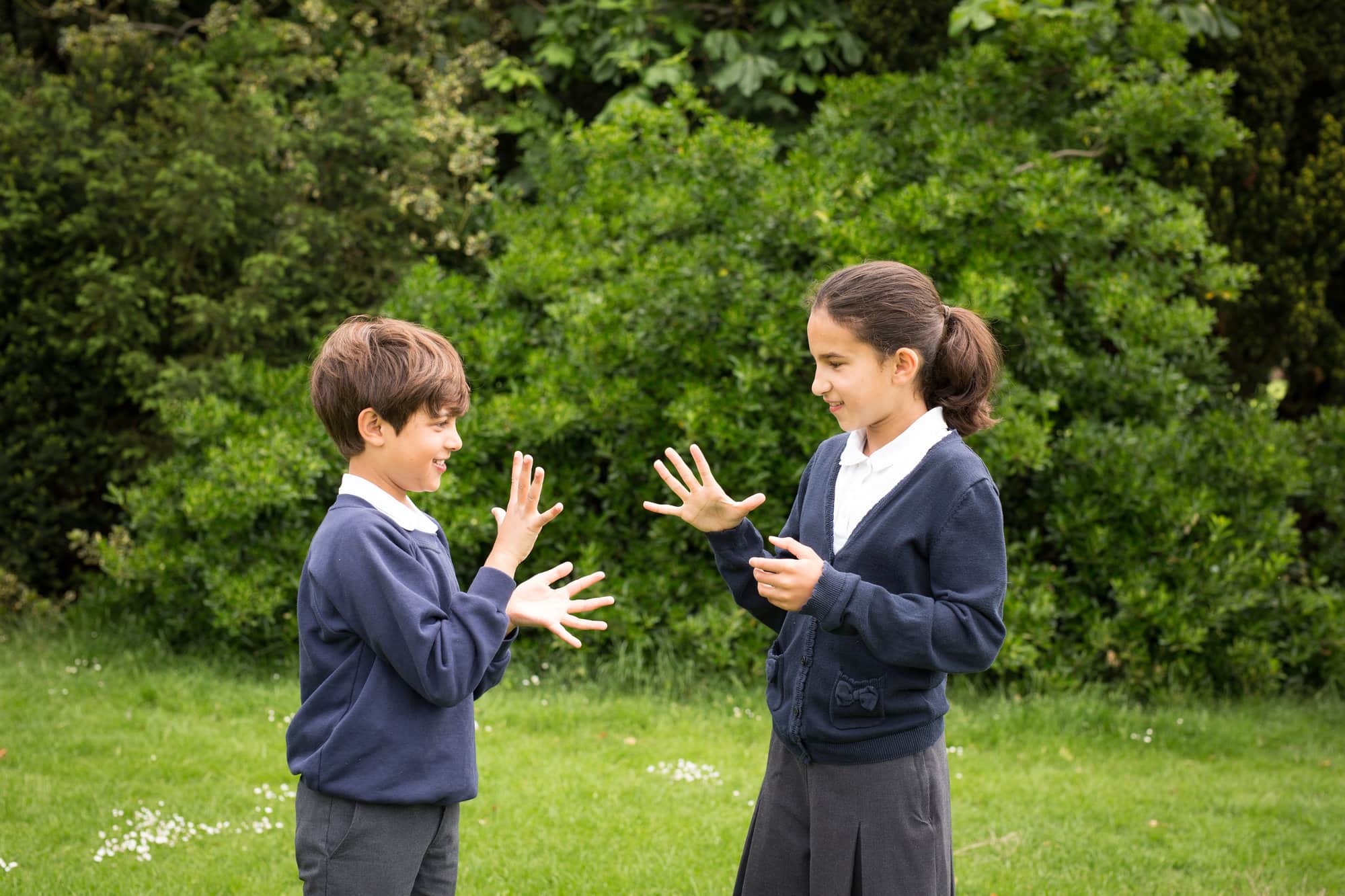 siblings playing in school uniform in park, taken by London school photographer
