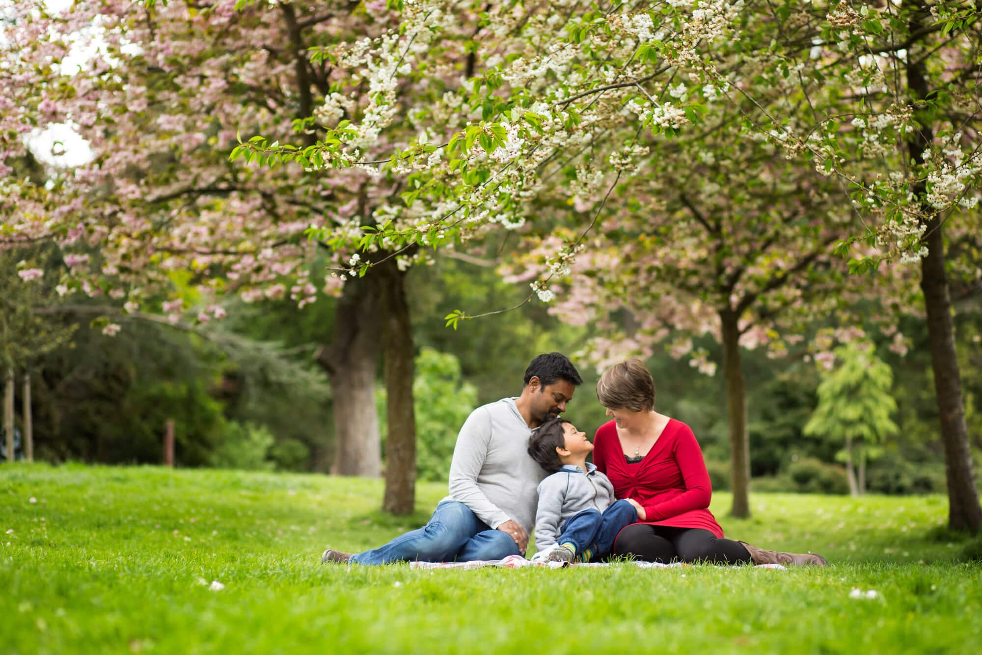 Family in Spring photos with blossom in the background taken in Beckenham park by Bromley family photographer