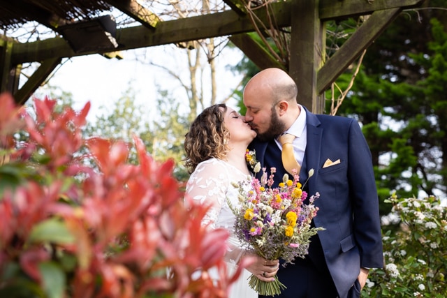 bride and groom kissing on wedding day at Oaks Farm Weddings taken by Beckenham Wedding Photographer