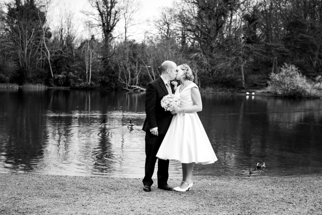 bride and groom standing by Keston Ponds on their wedding day