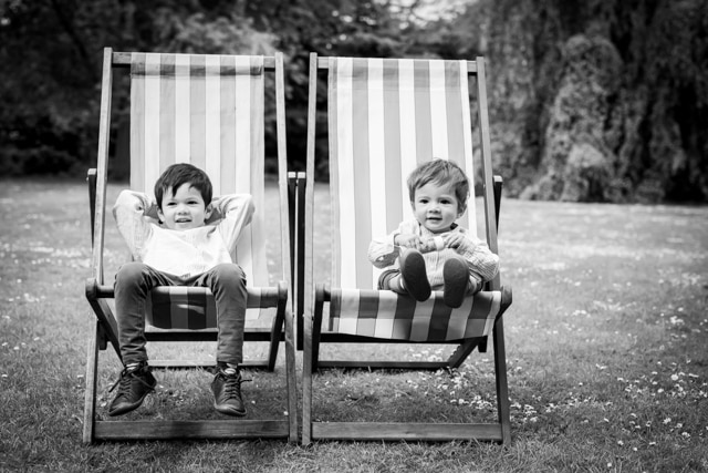 Brothers sitting in deckchairs in local park and relaxing in black and white photo from Bromley photoshoot