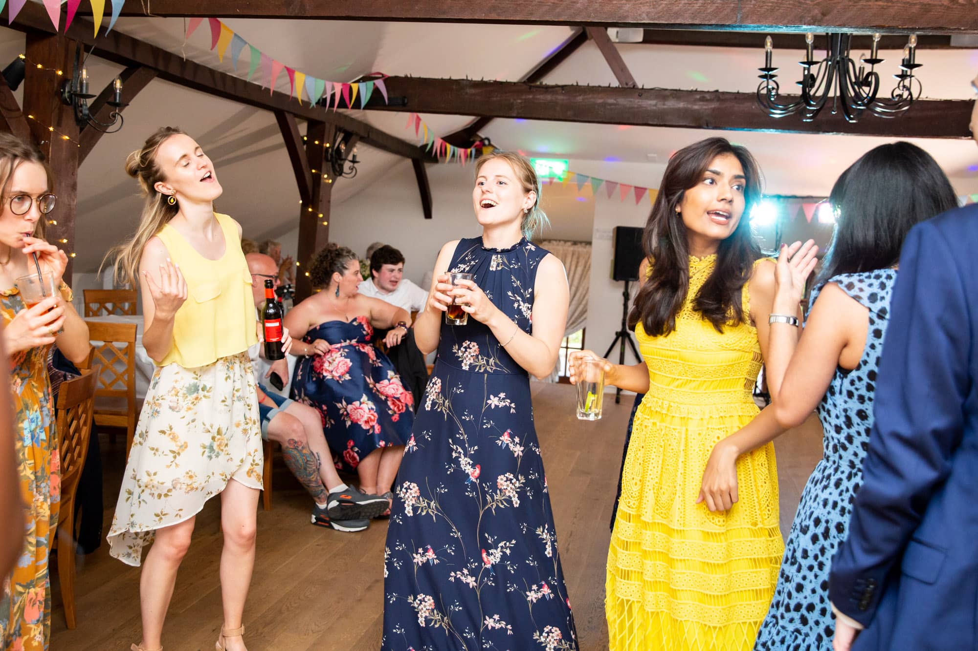 Guests dancing at wedding reception on dancefloor and singing in wedding photoshoot by Bromley photographer