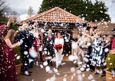 Confetti being thrown over bride and groom and captured by Bromley wedding photographer