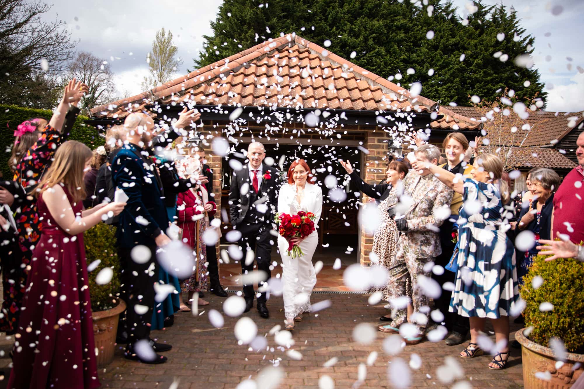 Confetti being thrown over bride and groom and captured by Bromley wedding photographer