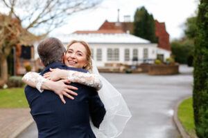 Bride and groom hugging on wedding day outside Oaks Farm Weddings venue taken by Beckenham Wedding Photographer