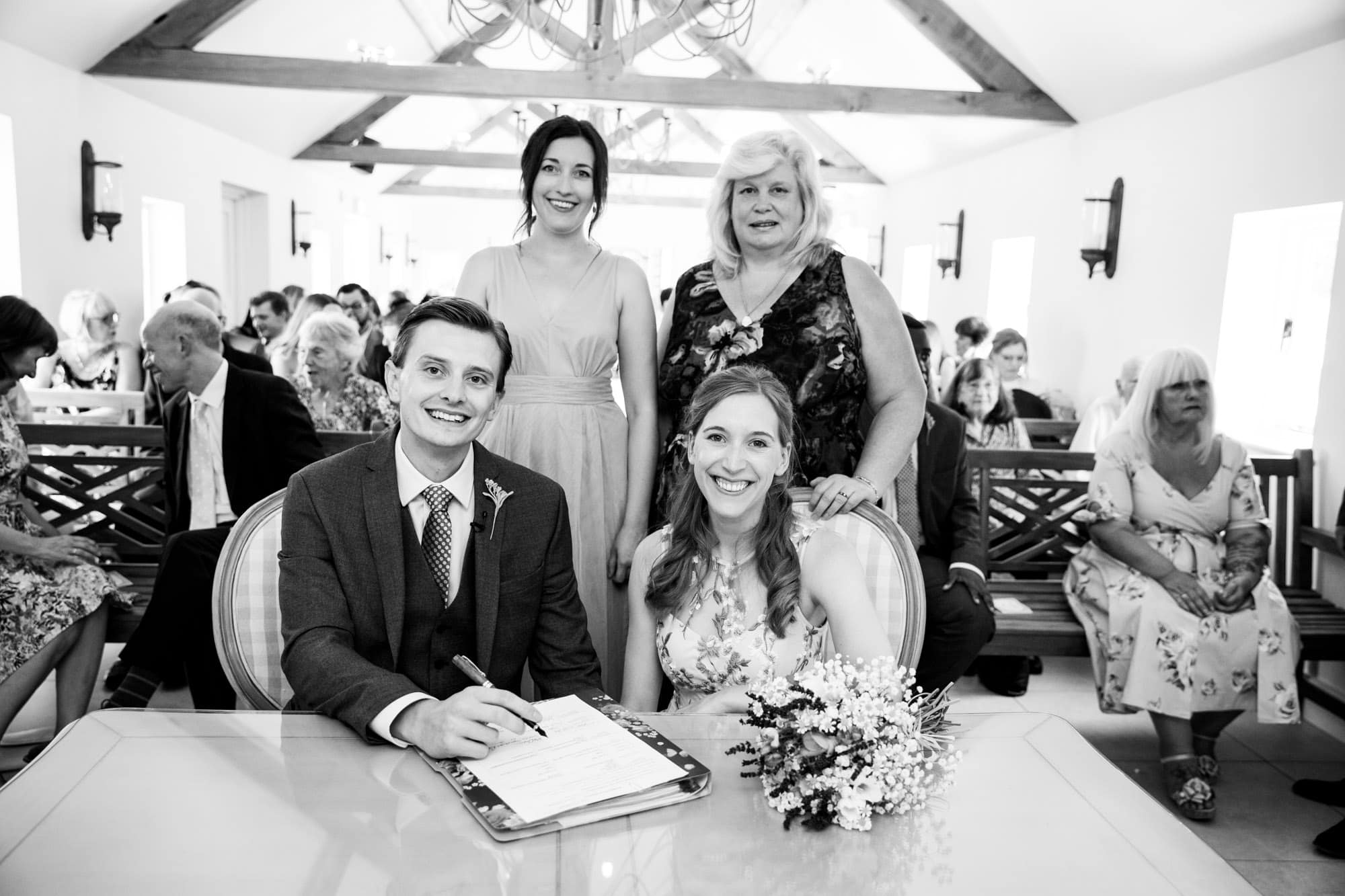 wedding couple signing the register with witnesses in wedding photoshoot near Bromley at Oaks Farm Weddings venue