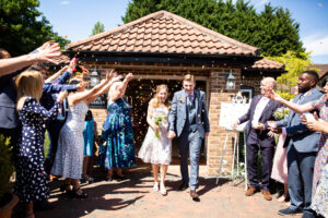 Bride and groom surrounded by confetti in wedding photo by Bromley photographer at Oaks Farm Weddings venue