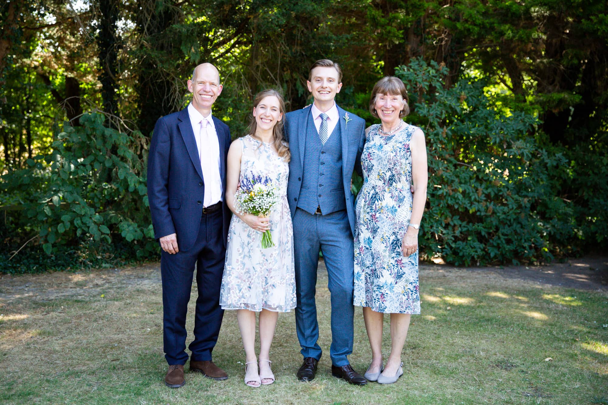 Bride and groom with parents in Family group wedding photo by Bromley photographer at Oaks Farm Weddings venue
