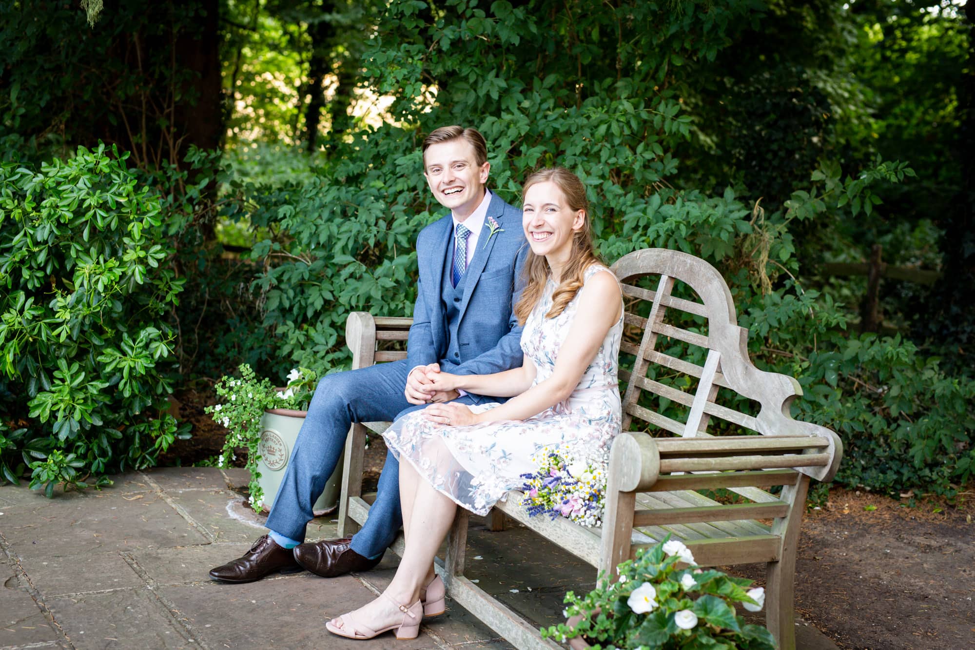 couple on bench after wedding sitting for wedding photography by local Bromley photographer at Oaks Farm Weddings
