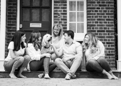 Family sat on front doorstep with their dog in black and white Bromley photoshoot