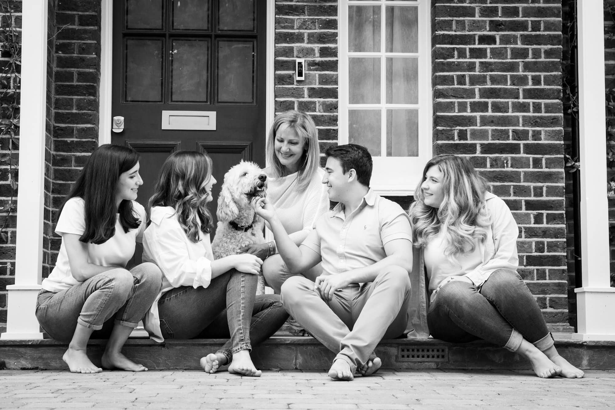 Family sat on front doorstep with their dog in black and white Bromley photoshoot
