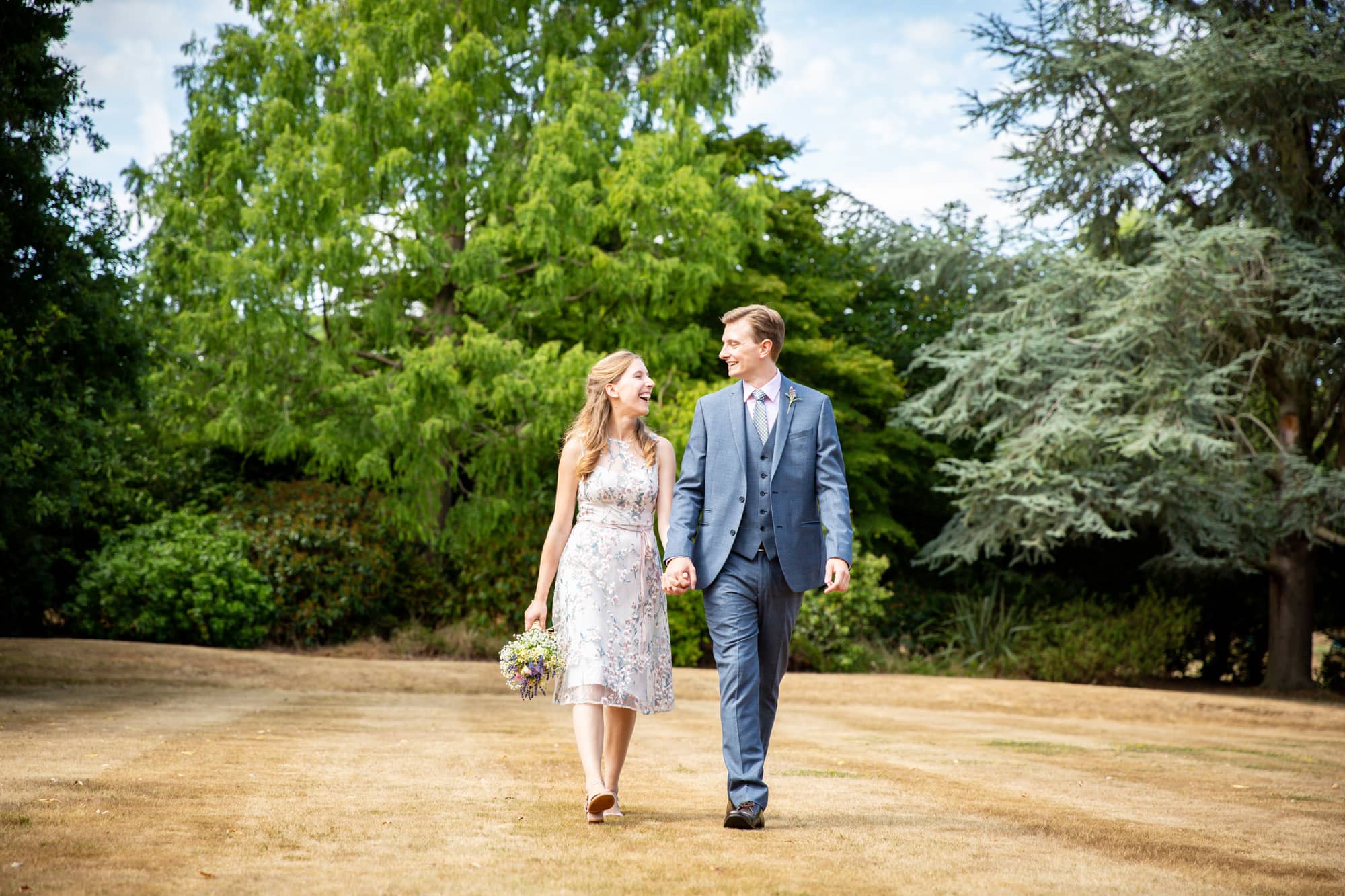 Wedding photograph in the Bromley area of couple walking hand in hand at Oaks Farm Weddings venue