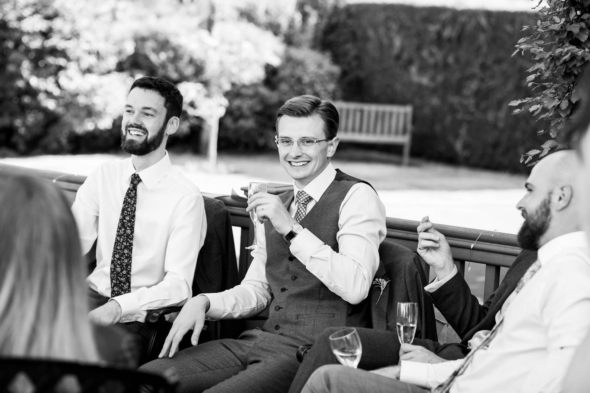 Groom and friends drinking and smiling at wedding reception at Oaks Farm Weddings taken by Bromley wedding photographer