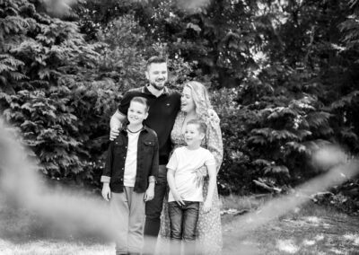Family in black and white photo in park laughing in Bromley family photoshoot
