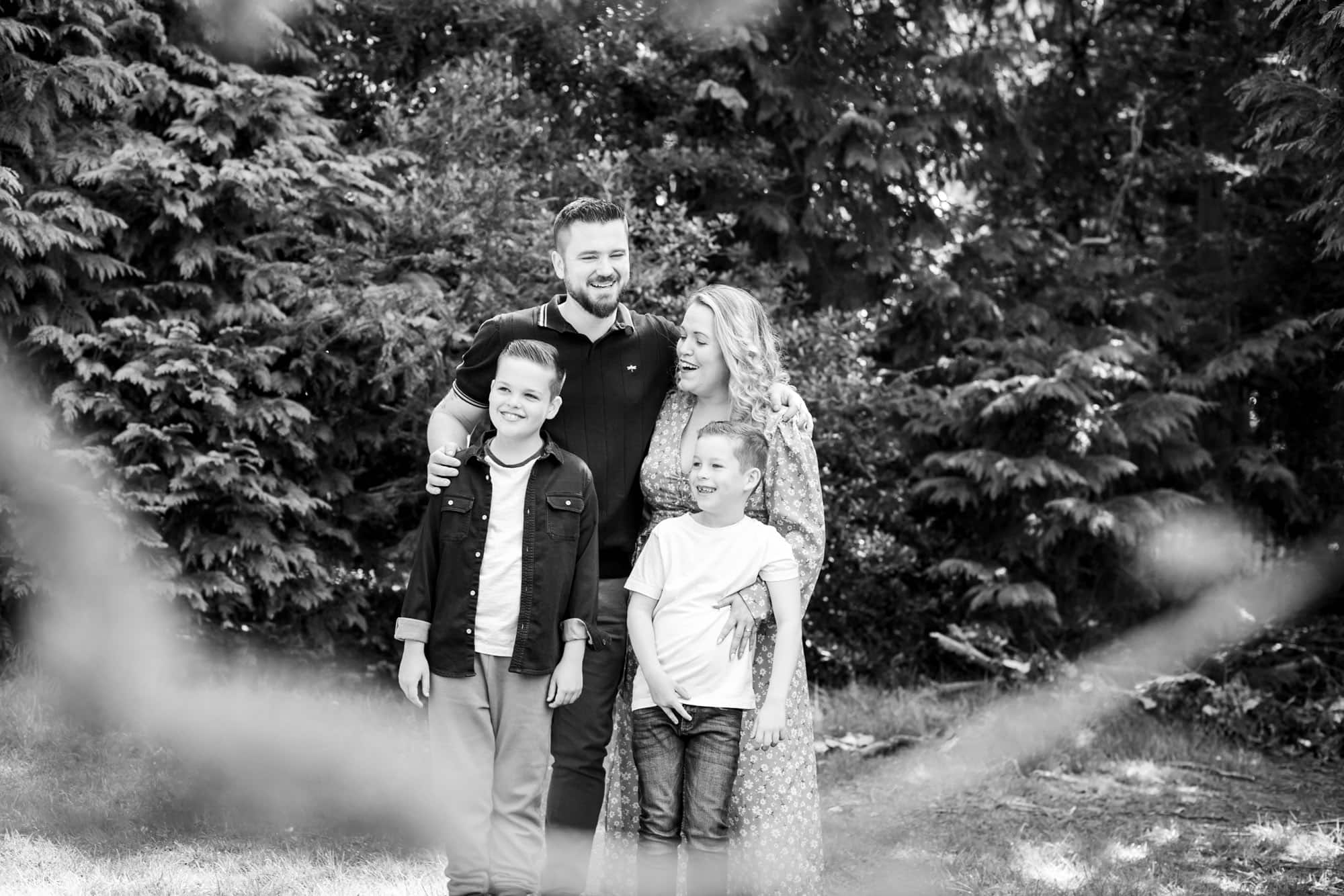 Family in black and white photo in park laughing in Bromley family photoshoot